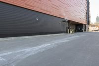 black building with a red roof with windows on both sides and yellow door frames in middle of driveway