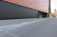 black building with a red roof with windows on both sides and yellow door frames in middle of driveway