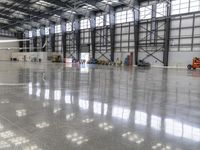 there is an industrial warehouse building with cement floors and large windows as workers work on a work