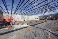 workers standing in front of a building under construction area in a parking lot near a large warehouse with concrete walls