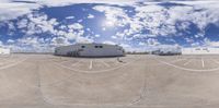 several storage trucks in the parking lot at an industrial site with cloudy sky and blue and white clouds