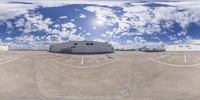 several storage trucks in the parking lot at an industrial site with cloudy sky and blue and white clouds