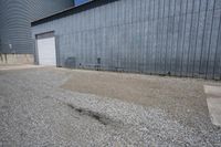 a concrete storage building sitting next to a white fenced area and two cement silos