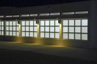 an empty building with two large windows next to it is dimly lit in the dark