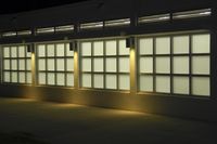 an empty building with two large windows next to it is dimly lit in the dark