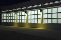 an empty building with two large windows next to it is dimly lit in the dark