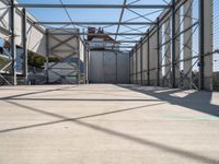 an industrial warehouse on a sunny day with sun casting shadows on the cement ground and walls