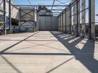 an industrial warehouse on a sunny day with sun casting shadows on the cement ground and walls