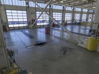 a large warehouse building with a metal and plastic flooring area and several workers working on equipment