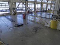 a large warehouse building with a metal and plastic flooring area and several workers working on equipment