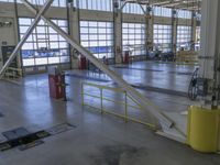 a large warehouse building with a metal and plastic flooring area and several workers working on equipment