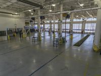 a large warehouse building with a metal and plastic flooring area and several workers working on equipment