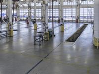 a large warehouse building with a metal and plastic flooring area and several workers working on equipment