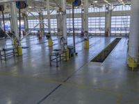 a large warehouse building with a metal and plastic flooring area and several workers working on equipment