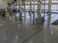 a large warehouse building with a metal and plastic flooring area and several workers working on equipment