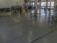 a large warehouse building with a metal and plastic flooring area and several workers working on equipment