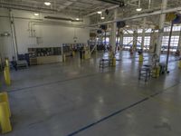 a large warehouse building with a metal and plastic flooring area and several workers working on equipment
