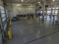 a large warehouse building with a metal and plastic flooring area and several workers working on equipment