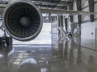 an airplane that is sitting inside of a hangar with a turbine on the ground in front of it