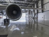 an airplane that is sitting inside of a hangar with a turbine on the ground in front of it