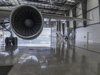 an airplane that is sitting inside of a hangar with a turbine on the ground in front of it