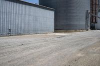 a view of an industrial warehouse with two tanks on a clear day with no clouds