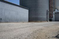 a view of an industrial warehouse with two tanks on a clear day with no clouds