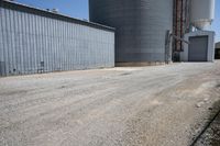 a view of an industrial warehouse with two tanks on a clear day with no clouds