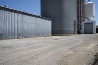 a view of an industrial warehouse with two tanks on a clear day with no clouds