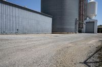 a view of an industrial warehouse with two tanks on a clear day with no clouds