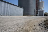a view of an industrial warehouse with two tanks on a clear day with no clouds