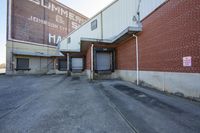 a brick building with an air duct and a white hose sticking out of it in front of it