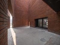 an open, very large room that is made from brick walls with sliding doors on each side