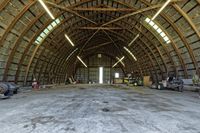 two large grain bins sit in the center of a field, surrounded by silos