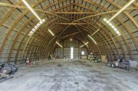 two large grain bins sit in the center of a field, surrounded by silos