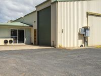 an industrial building with a metal door and doors open to show air condition on top