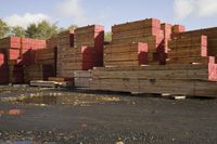 a group of wooden lumber stacked on top of each other on a pile of bricks