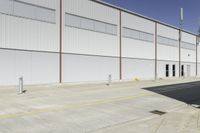 a street next to an industrial warehouse with a yellow line drawn in between the two buildings