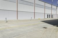 a street next to an industrial warehouse with a yellow line drawn in between the two buildings