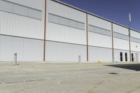 a street next to an industrial warehouse with a yellow line drawn in between the two buildings