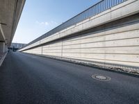 an empty street and an overpass under a bridge that runs through town, and across town