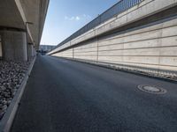 an empty street and an overpass under a bridge that runs through town, and across town