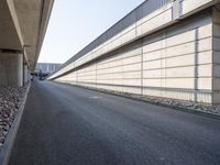 an empty street and an overpass under a bridge that runs through town, and across town