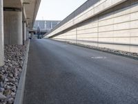 an empty street and an overpass under a bridge that runs through town, and across town