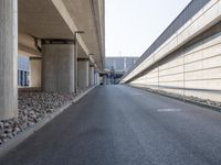 an empty street and an overpass under a bridge that runs through town, and across town