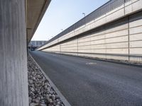 an empty street and an overpass under a bridge that runs through town, and across town