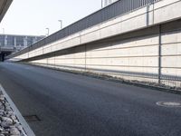 an empty street and an overpass under a bridge that runs through town, and across town