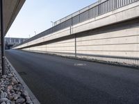 an empty street and an overpass under a bridge that runs through town, and across town