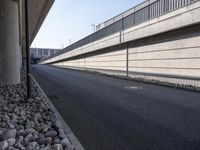 an empty street and an overpass under a bridge that runs through town, and across town