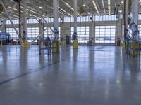 a warehouse filled with lots of empty machines and a blue chair in the middle of the room